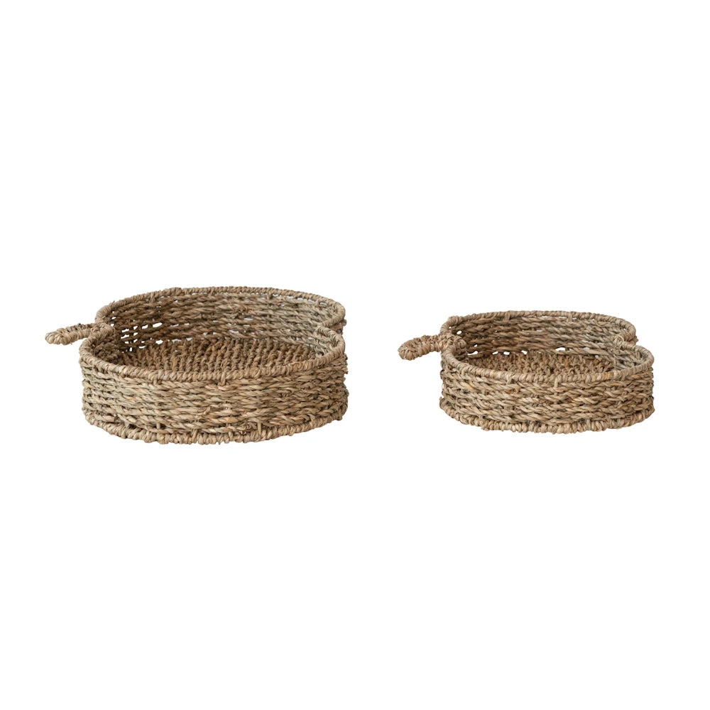 Two hand-woven, pumpkin-shaped seagrass trays in different sizes, featuring natural textures and woven stems.