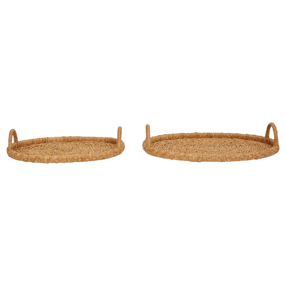 Two round, hand-woven natural seagrass trays with handles, shown side-by-side on a plain white background.