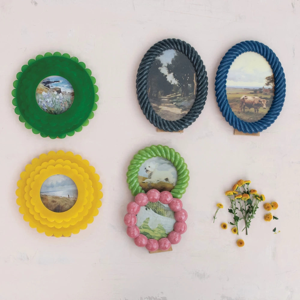 A collection of colorful handmade resin photo frames in scalloped, rope, and bubble textures with landscape art prints.