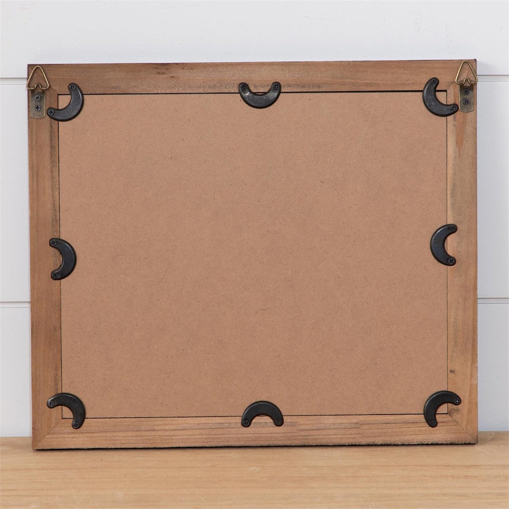 Back view of a wooden picture frame with a cardboard backing, hanging hardware, and black metal turn buttons.