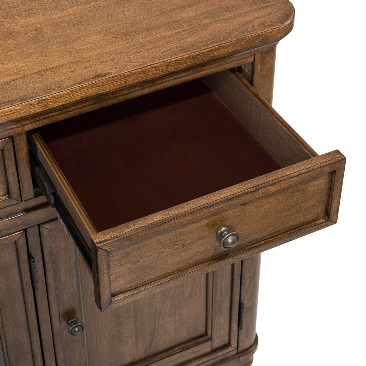 Open felt-lined drawer of a Harrison Heights wood buffet, highlighting the brown finish and metal knob hardware.