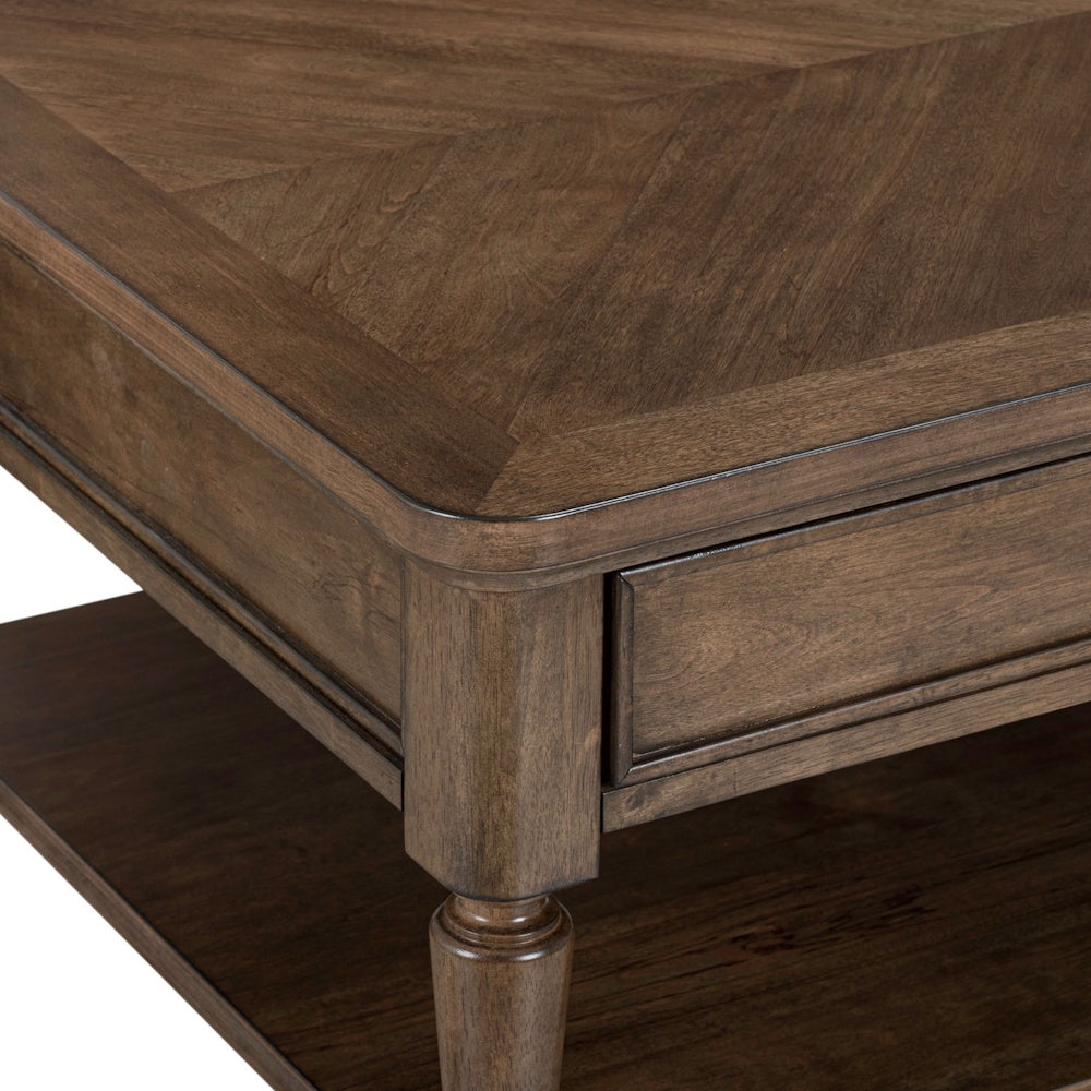 Close-up of a brown wood coffee table corner showing a parquet pattern top, drawer detail, and turned leg.