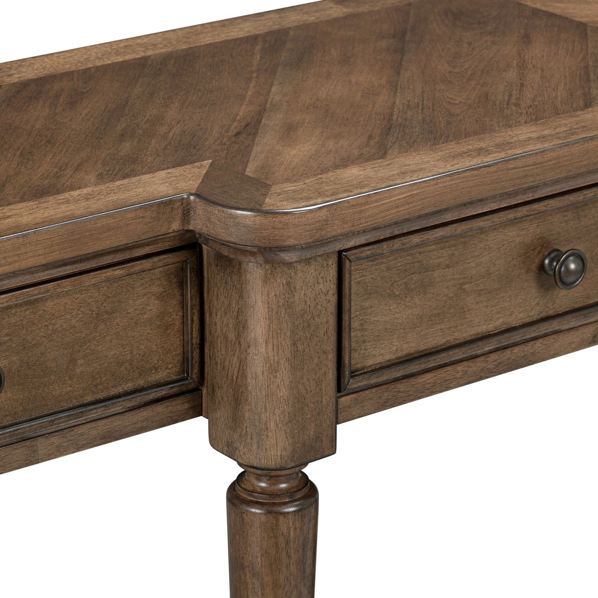 Close-up of a wood console table showing the chevron pattern tabletop, curved corner, and drawer hardware.