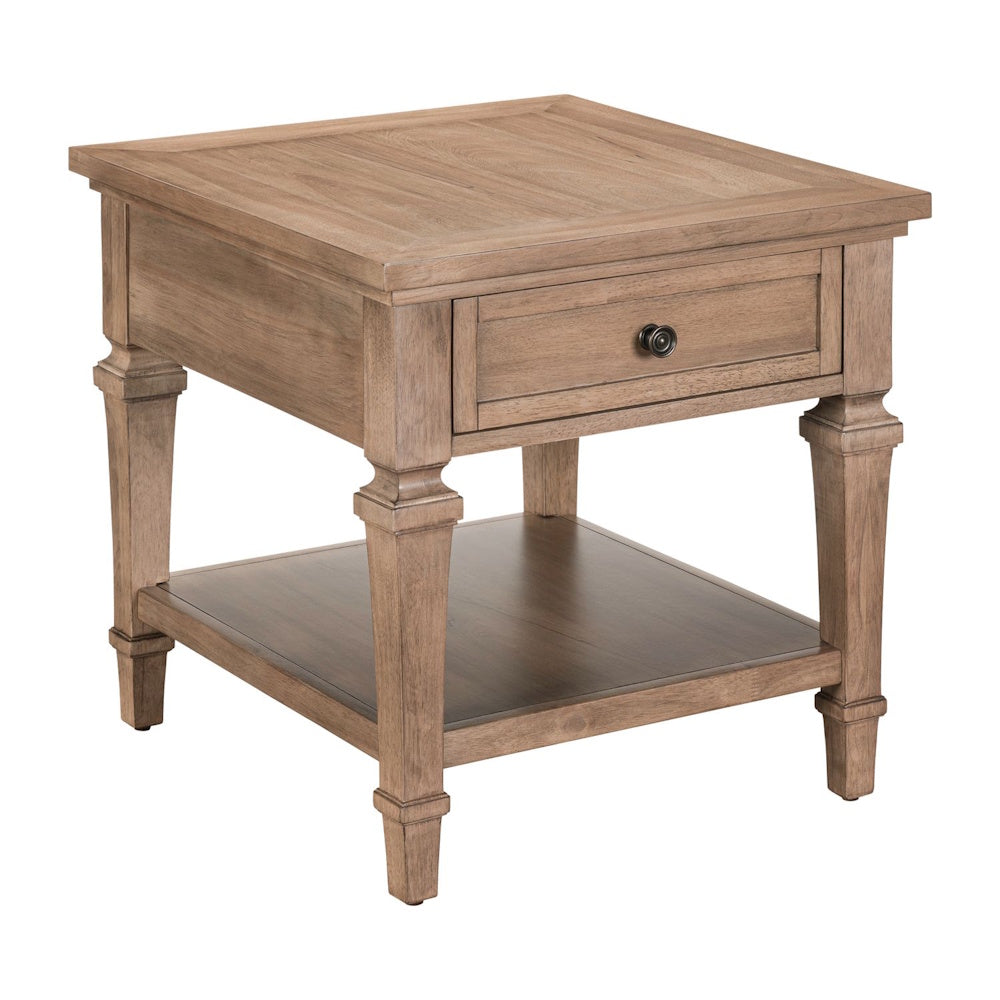 Wood end table with drawer, lower shelf, and tapered legs in a light natural finish.