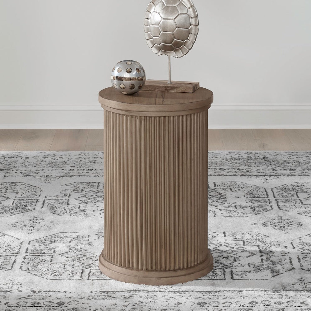 Round wood chairside table with fluted pedestal base styled in a modern farmhouse living room.