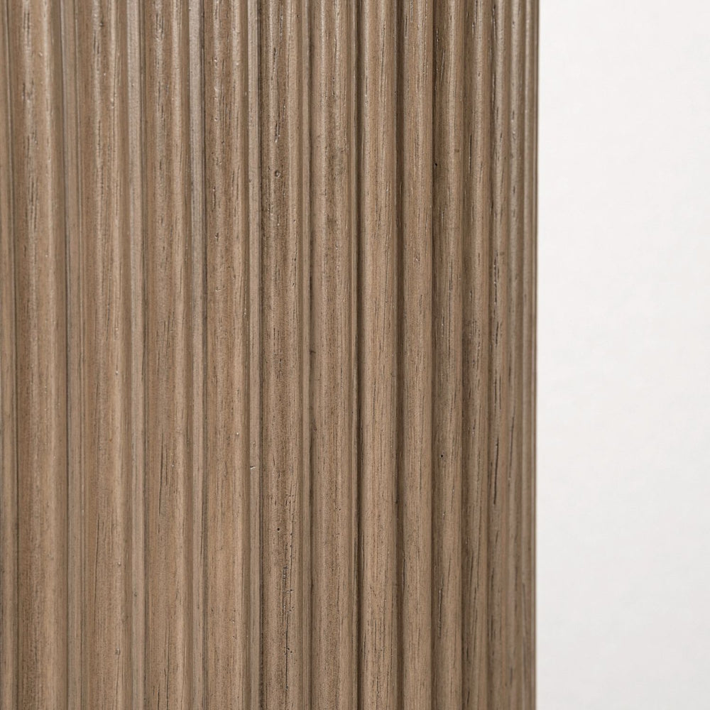 Close-up of fluted wood pedestal base with natural grain on round farmhouse chairside table.