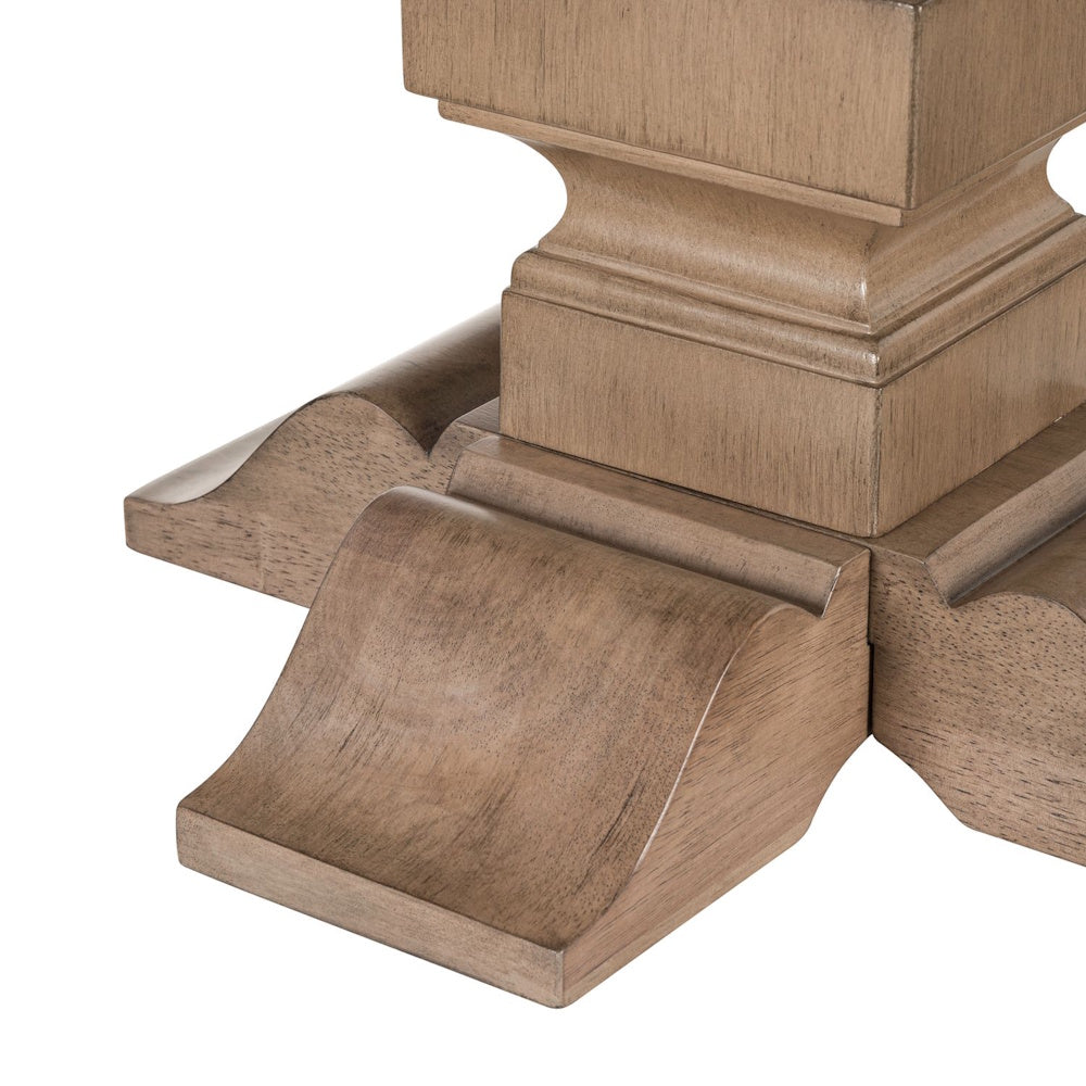 Close-up of carved wooden table base with curved feet in a light natural finish.
