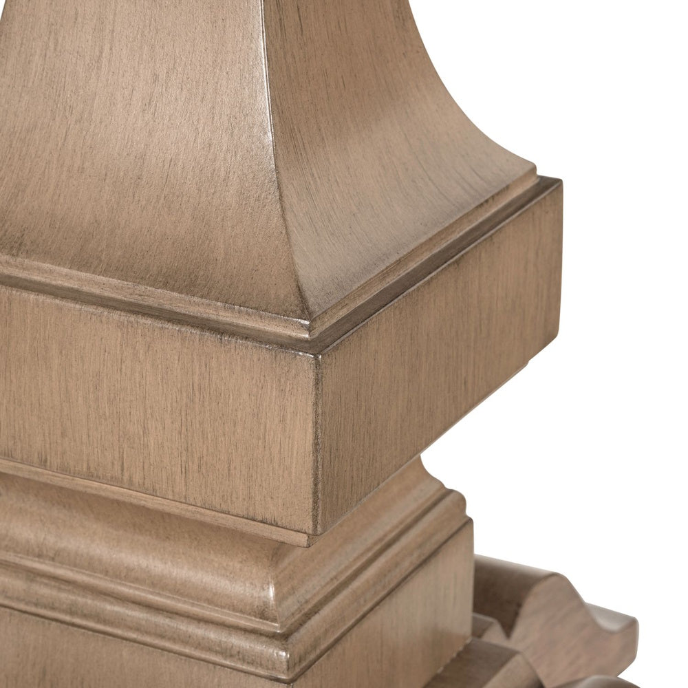 Close-up of light wood pedestal base with carved detailing and natural finish.