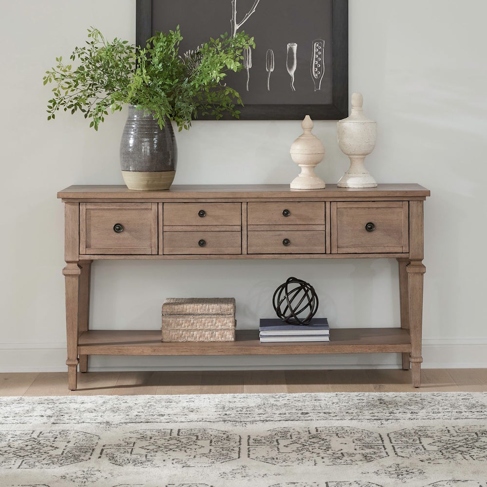 Light wood farmhouse sofa table with six drawers and lower shelf styled in a cozy living room.