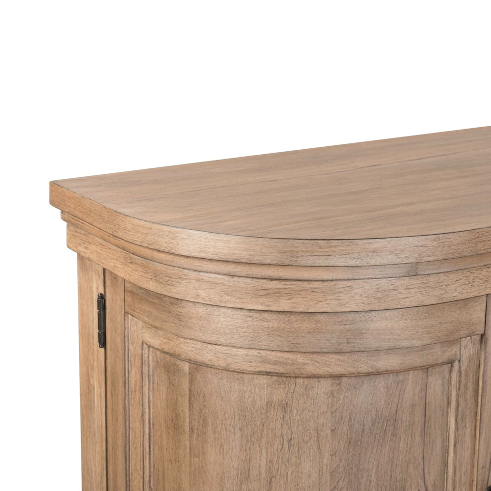 Close-up of a light wood TV console featuring a curved corner and paneled cabinet door.