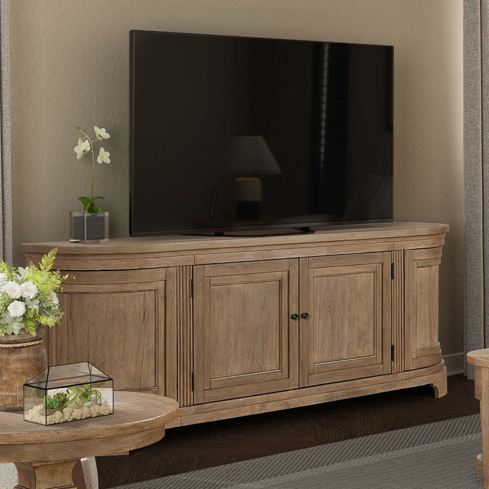 Wooden media console with curved ends and four cabinet doors supporting a large flat-screen TV in a living room.