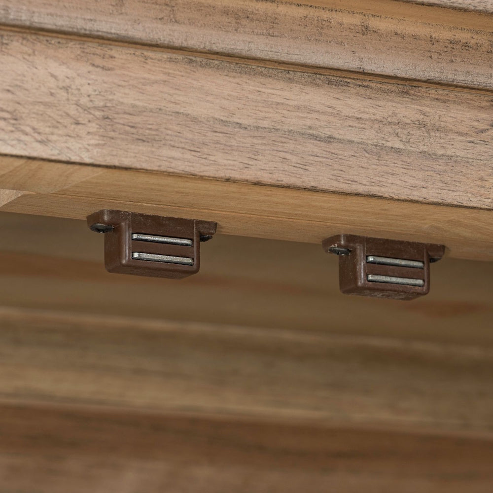 Close-up of two brown magnetic door catches mounted to the underside of a light wood furniture shelf.