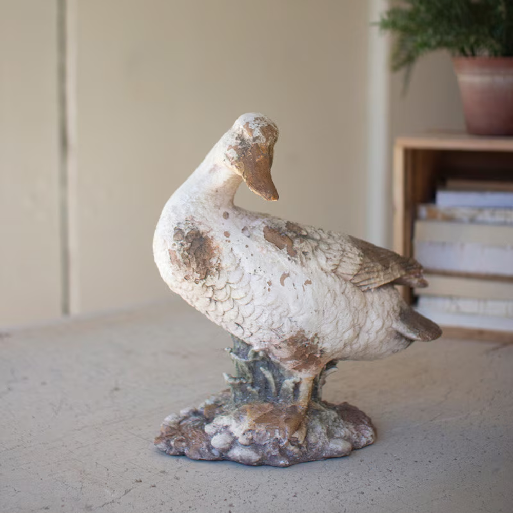 Rustic duck statue with head turned downward, featuring a distressed, faux-concrete finish.