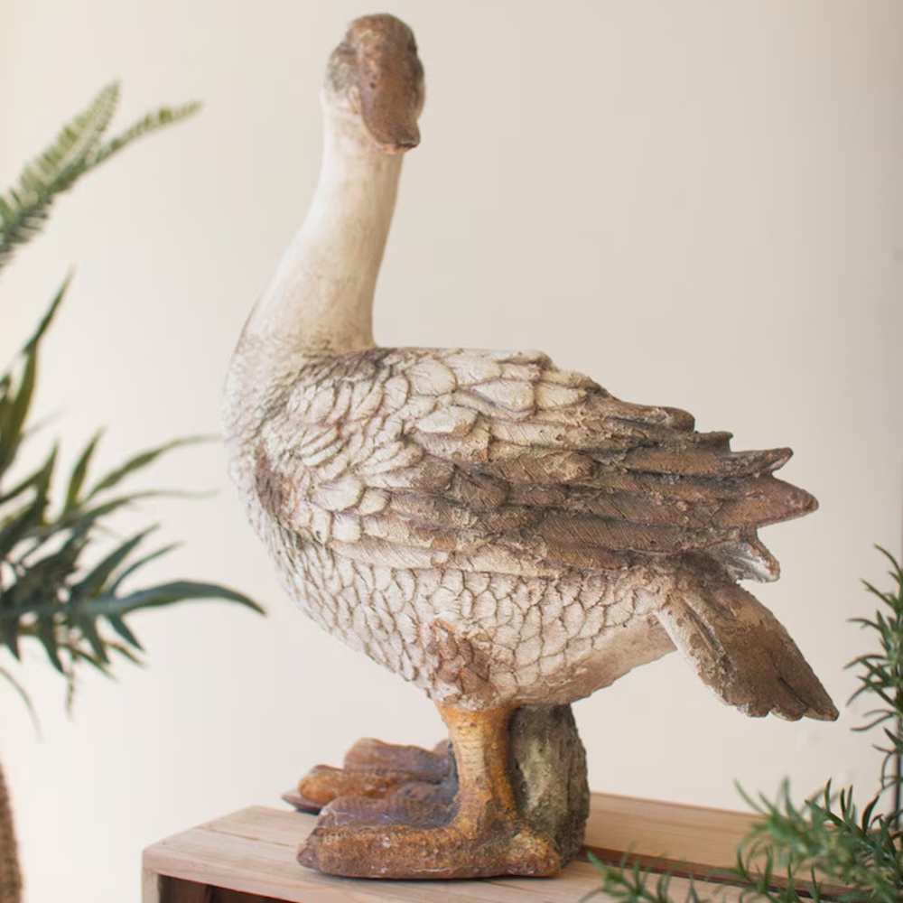 Rustic duck statue standing with neck extended upward, featuring a distressed concrete finish.