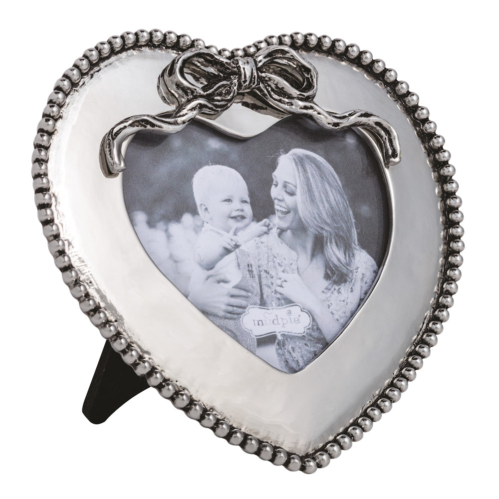 Silver heart-shaped picture frame with beaded trim and a bow detail, holding a black and white family photo.