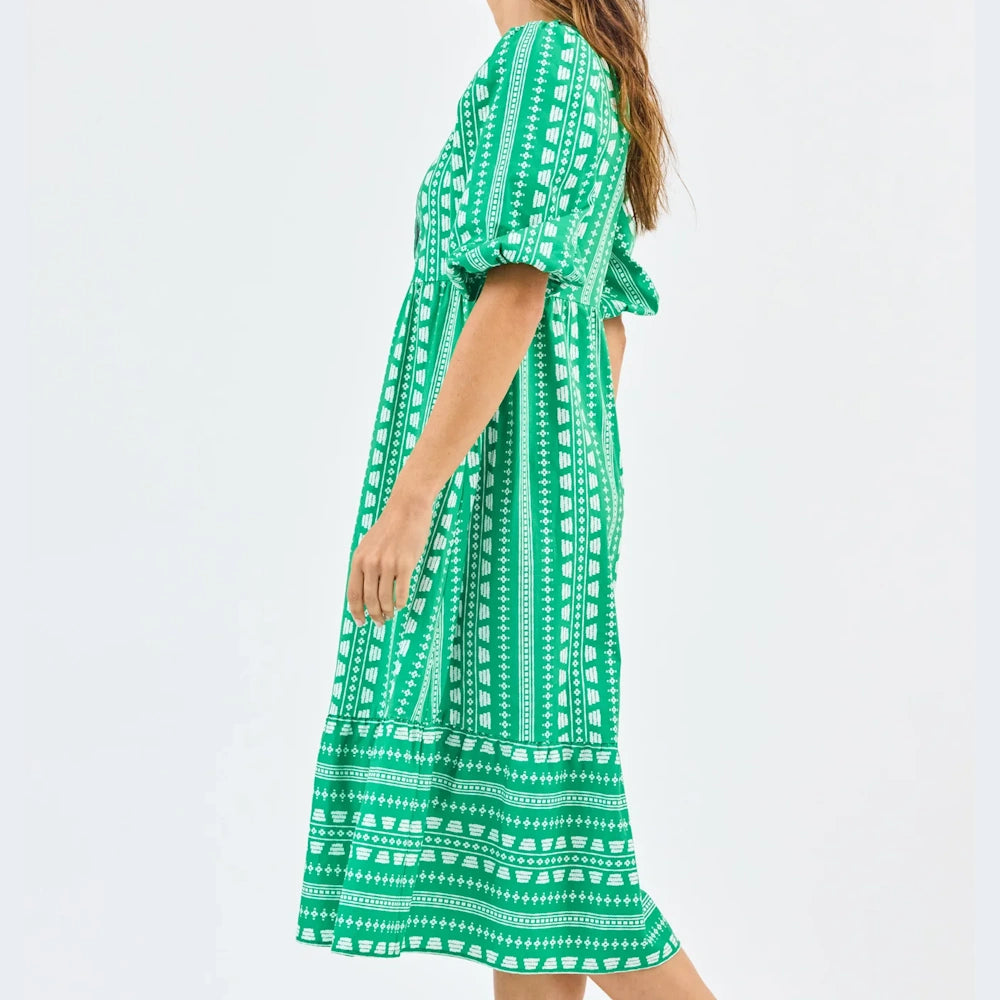 Green midi dress with a white heritage stitch pattern, puff sleeves, and a tiered skirt on a model.