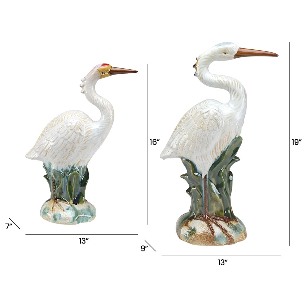 Two ceramic heron figurines with measurements for height, width, and depth indicated by black line markers.