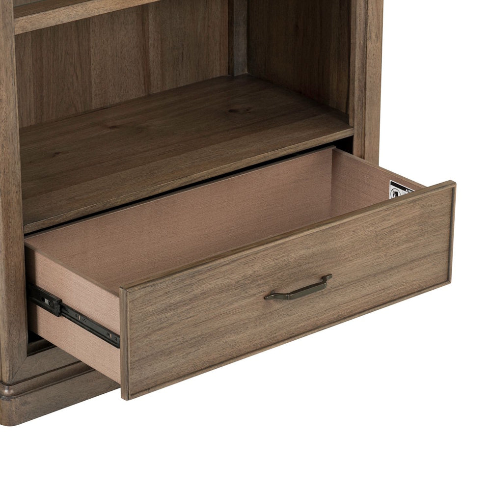 Close-up of an open bottom drawer on a Hickory Grove wood bookcase showing metal glides and handle.