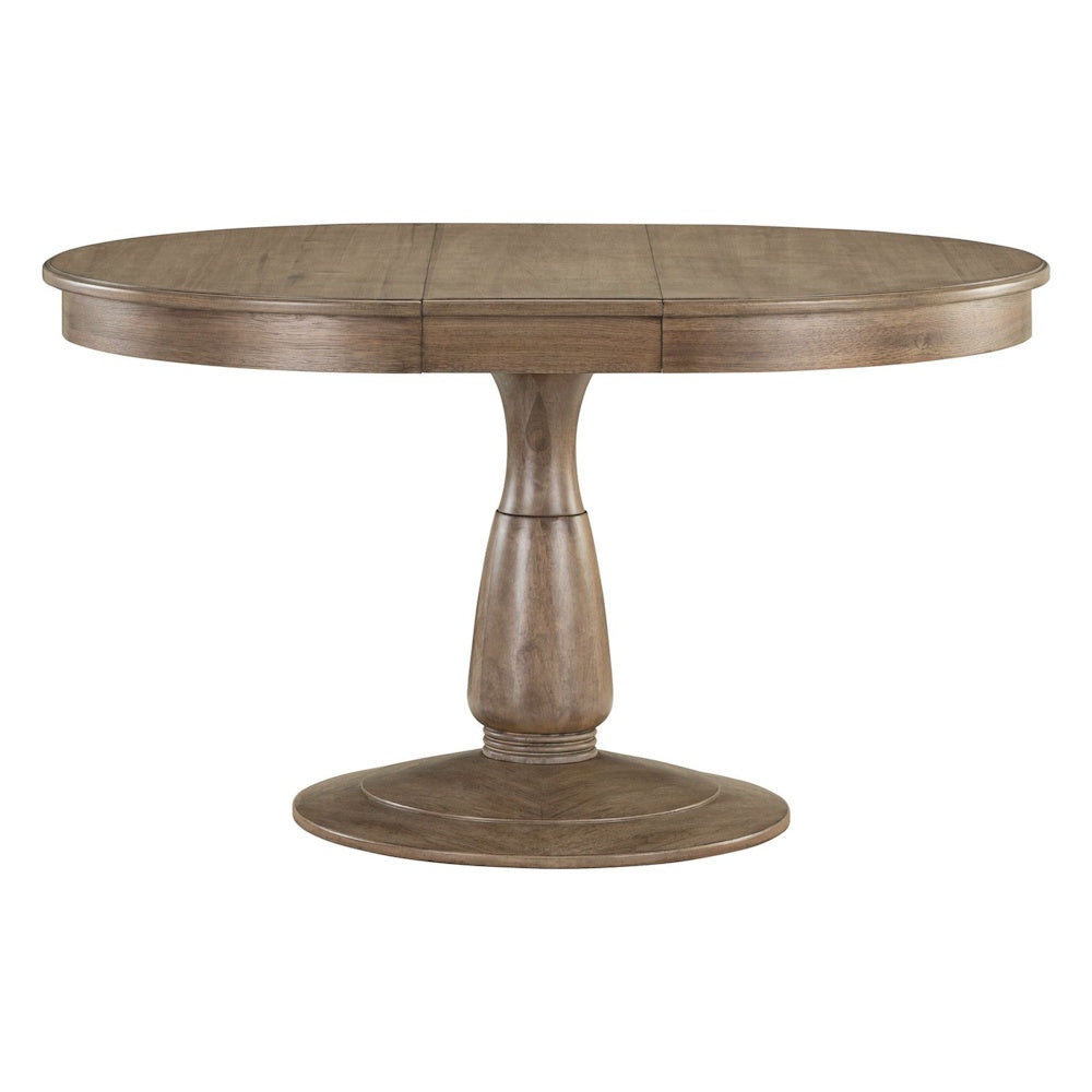 Round wood pedestal dining table with an extension leaf in a light brown finish.