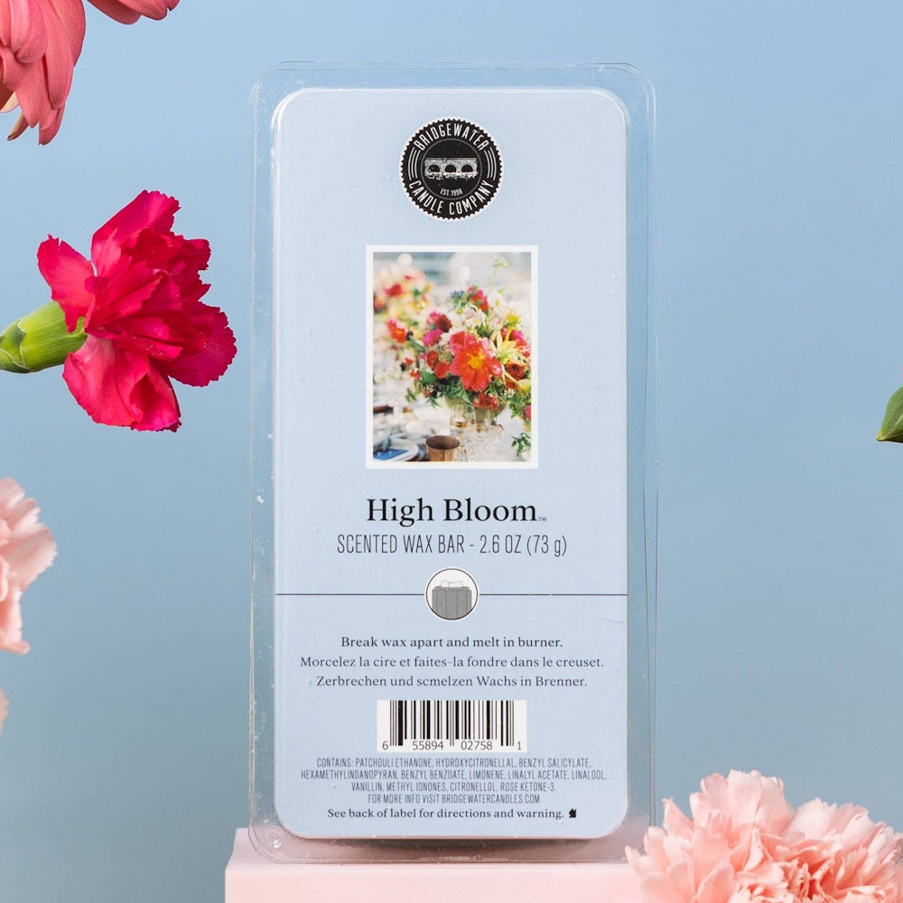 Bridgewater Candle Company High Bloom scented wax bar with floral packaging and pink carnations on a blue background.