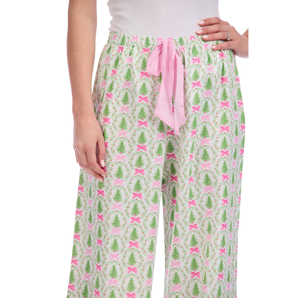 Holiday pajama pants with green Christmas trees, pink bows, and a pink drawstring tie on a white background.