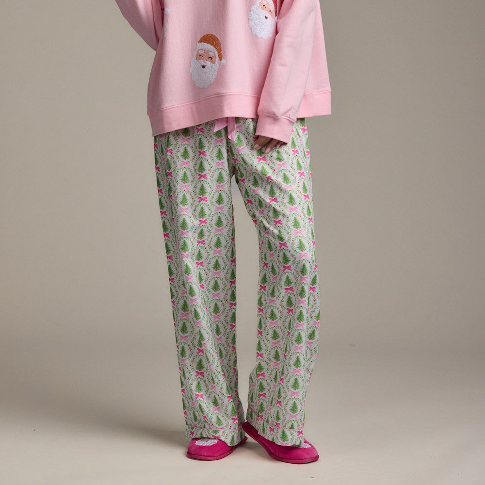Holiday pajama set with Christmas tree print pants, pink Santa sweatshirt, and fuzzy pink slippers.