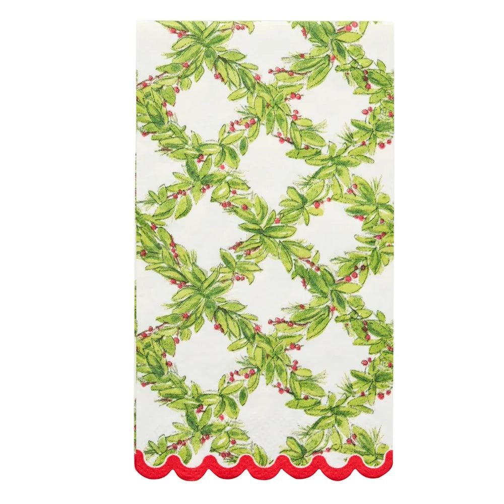 Front flat lay of a white paper guest towel with a green holly pattern and a red scalloped edge.