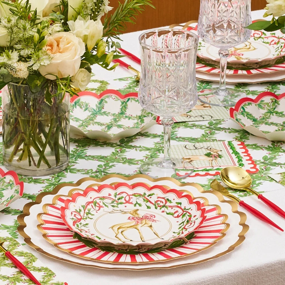 Angled view of red and white paper holiday salad plates styled on a festive table setting.
