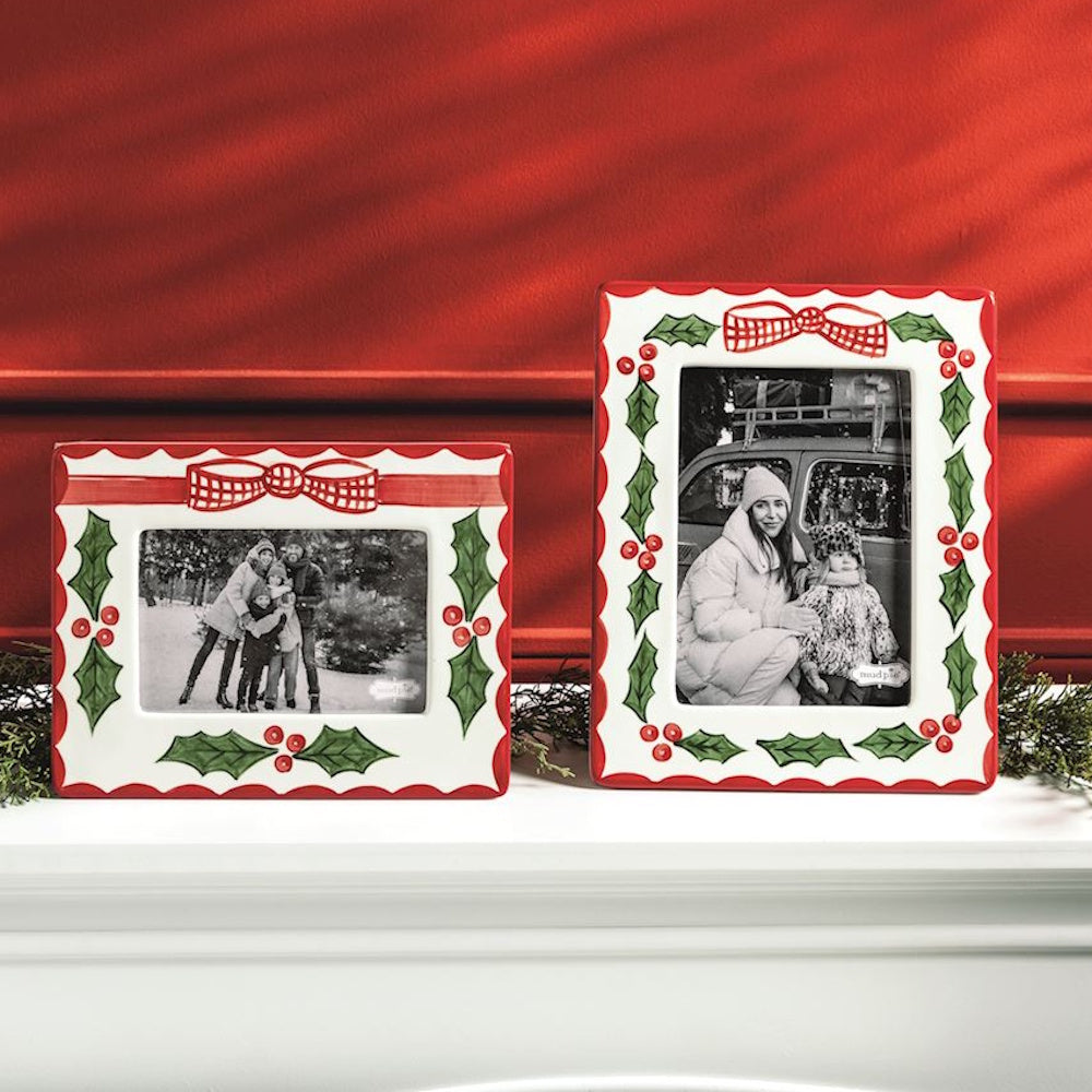 Two hand-painted ceramic picture frames with red scalloped borders, bows, and holly leaves with berries.