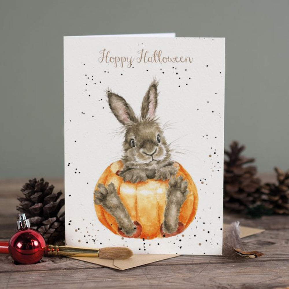 Greeting card featuring a cute bunny inside a pumpkin with text reading "Hoppy Halloween".