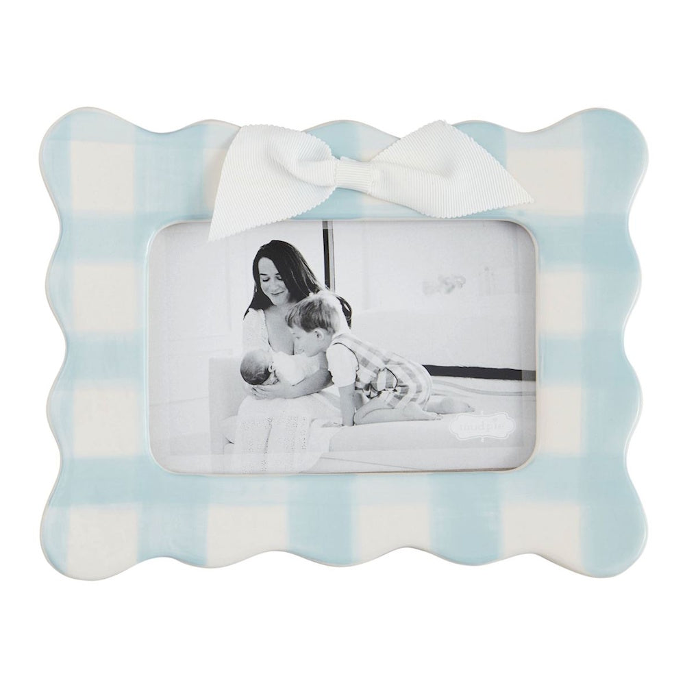 Light blue and white gingham scalloped picture frame with a white bow and a black and white family photo.