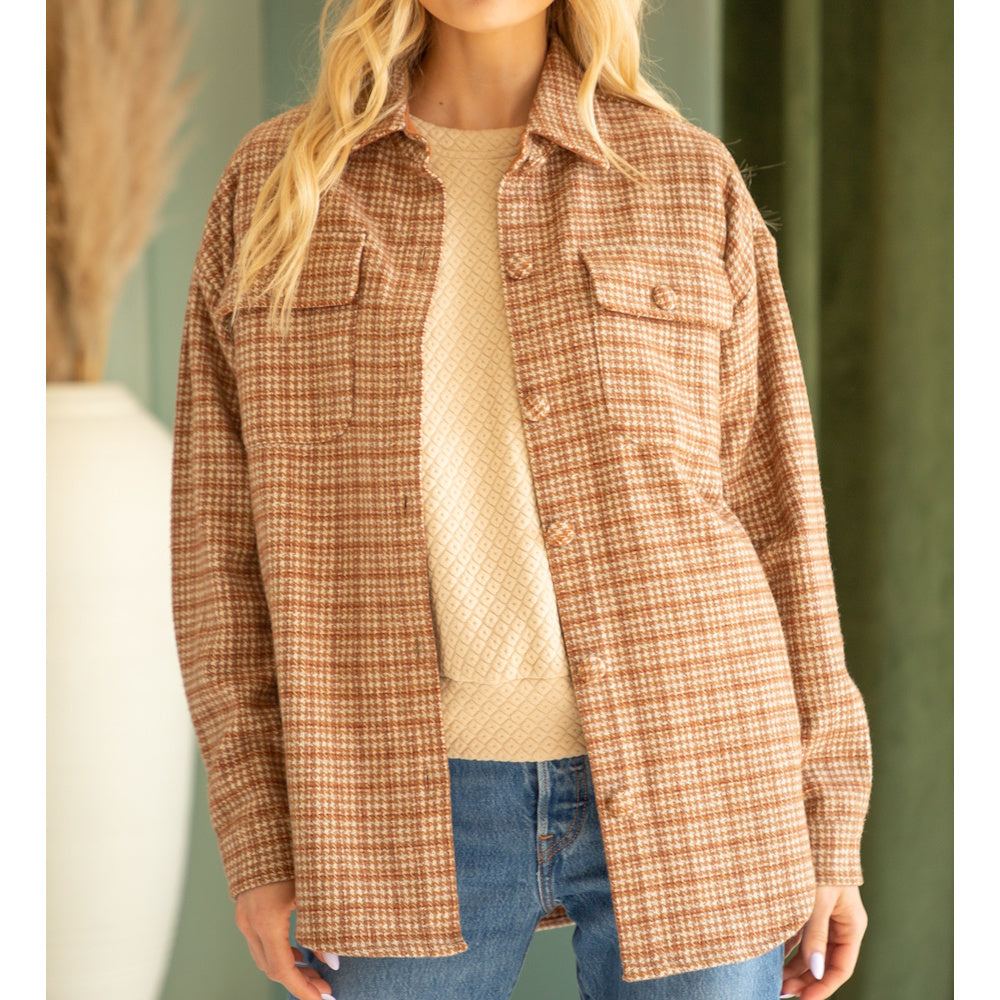Front view of a brown houndstooth plaid shacket worn open over a beige knit top and jeans.