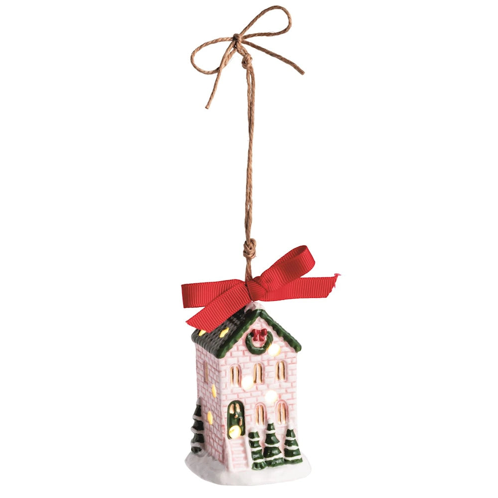 Lighted ceramic house ornament with red bow and twine hanging loop.