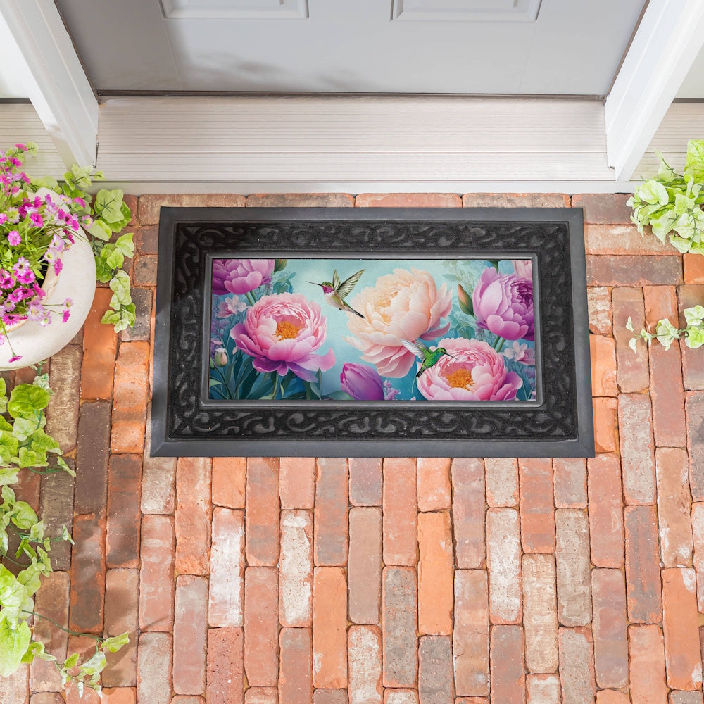 Hummingbird and pink peony floral door mat on a brick porch. Decorative spring welcome mat and garden-themed entryway decor.
