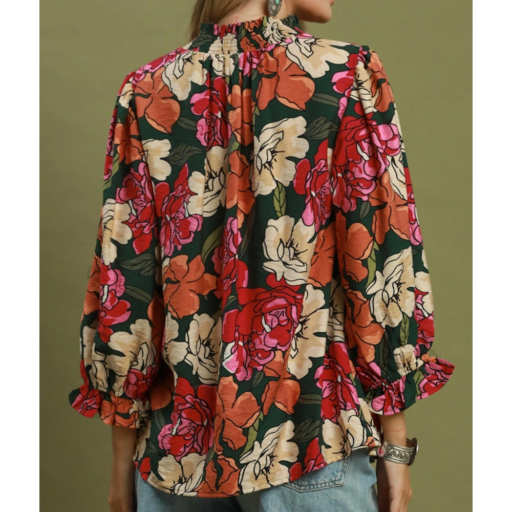 Back view of a hunter green floral print blouse with a smocked collar.