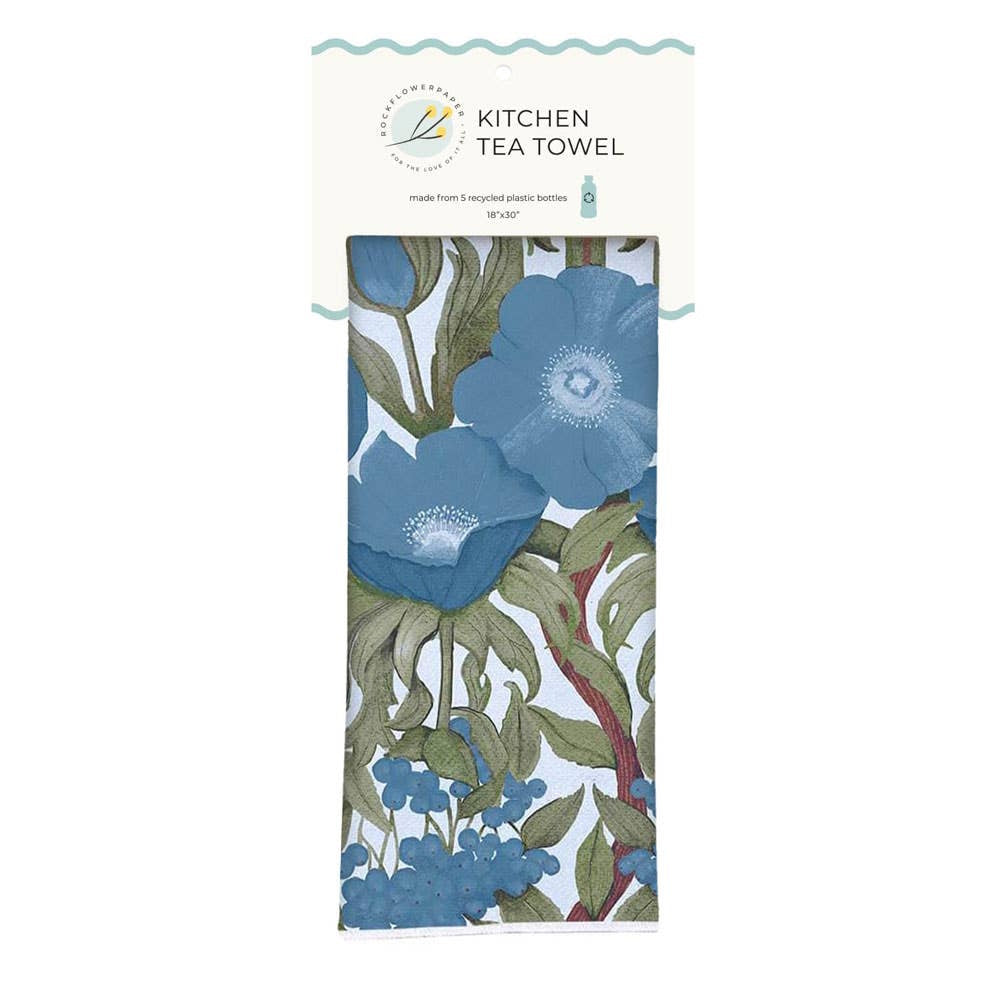 Folded kitchen tea towel featuring large blue poppies and green leaves, attached to a product tag.