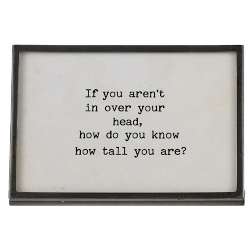 Gunmetal finish metal and glass frame with an easel back featuring the quote "If you aren't in over your head, how do you know how tall you are?"