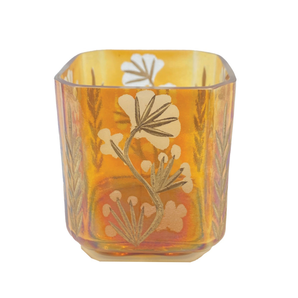 Side view of the iridescent amber glass votive holder showing the etched floral design and rounded corners.
