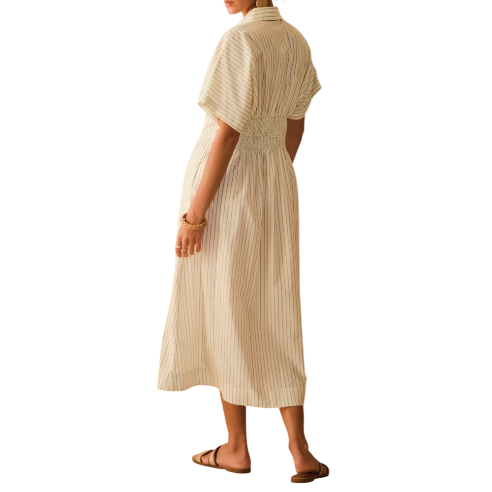 Back view of a person wearing an ivory pin-striped cotton midi shirt dress with a smocked waist.