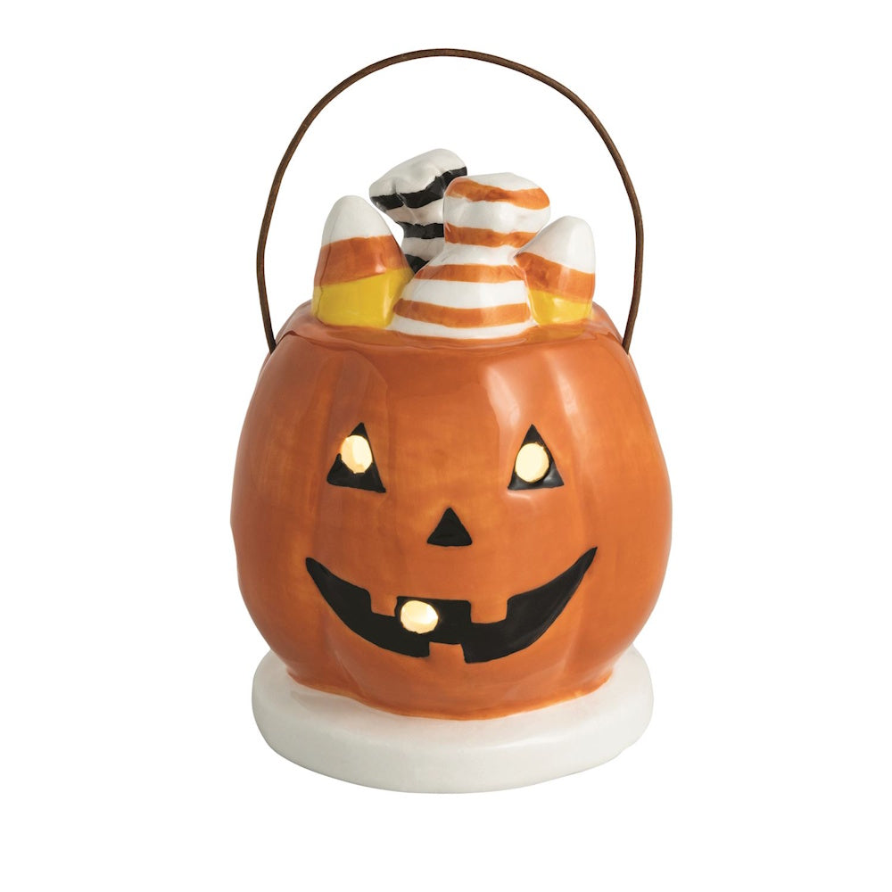 Light-up ceramic jack-o'-lantern basket Halloween table decor filled with candy corn treats.
