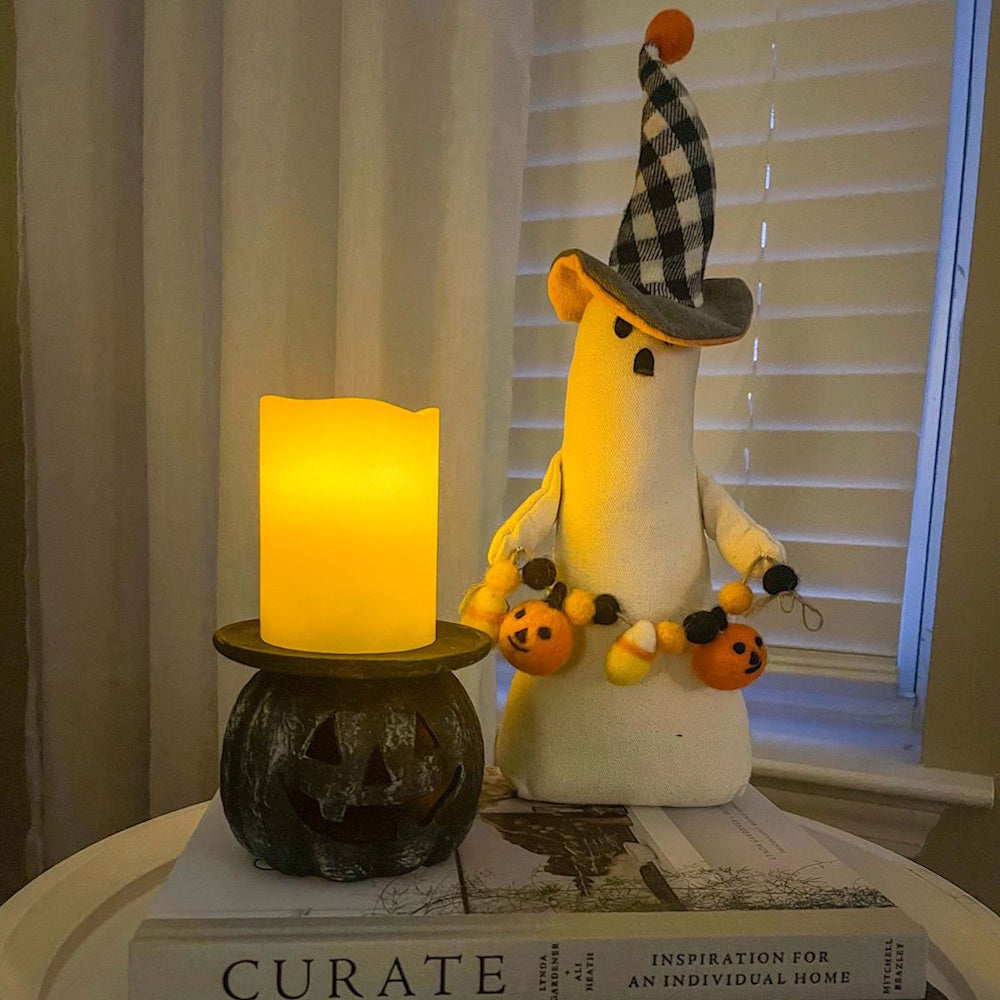 Jack-o'-lantern candle holder and fabric ghost Halloween table decor.
