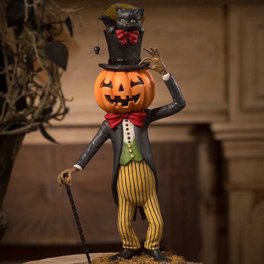 Dapper jack-o'-lantern figure tipping a top hat with a black cat inside, holding a cane.