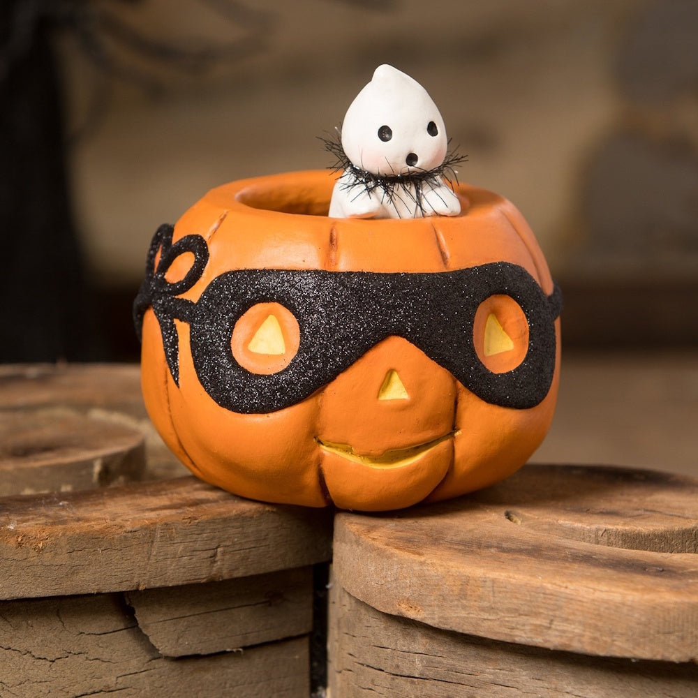 Cute pumpkin figure wearing a black glittery mask with a small ghost peeking out from the top.