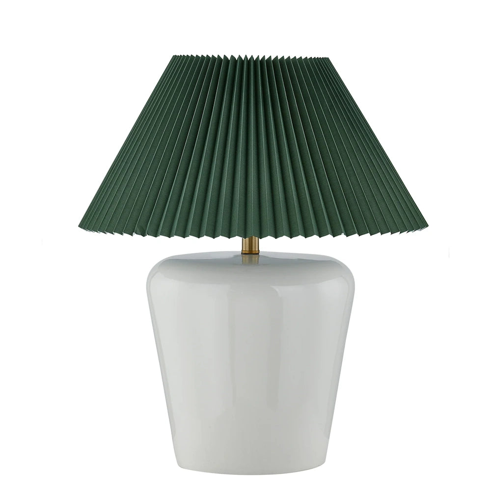 Glossy white ceramic table lamp with dark green pleated shade and brass accent hardware.