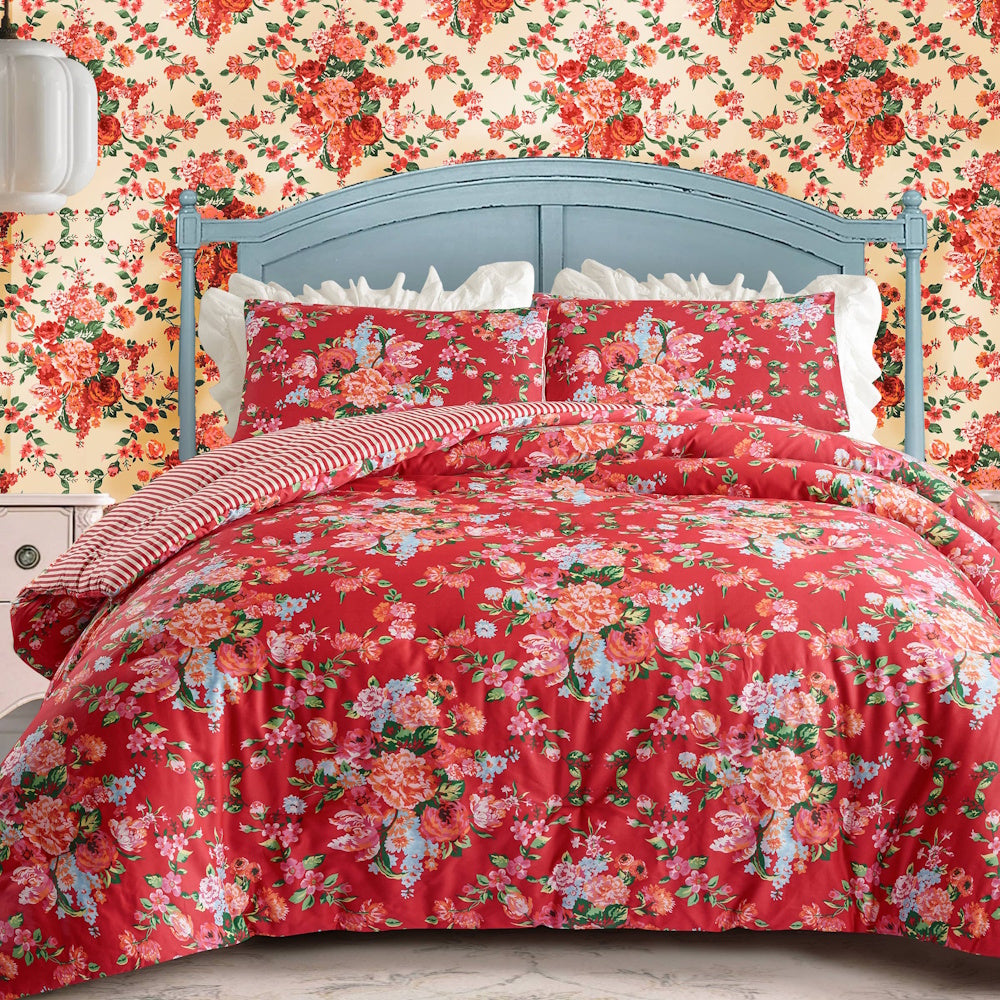 Junk Gypsy Garden Society red floral comforter set on a blue headboard with matching floral wallpaper and ruffled pillows.