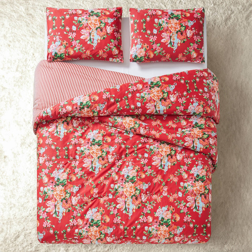 Red floral Junk Gypsy Garden Society comforter set with striped reverse and matching pillows on a white shag rug.
