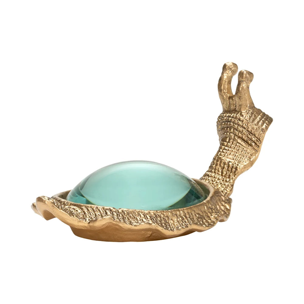 Side profile view of a brass snail paperweight featuring a round magnifying glass lens set in its shell.