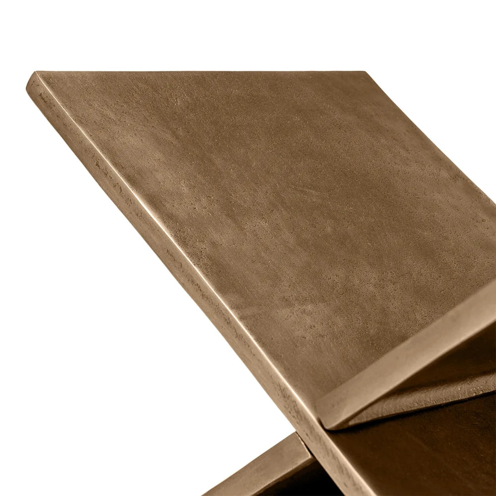 Close-up of a textured, bronze-finished metal book holder with clean angles against a white background.