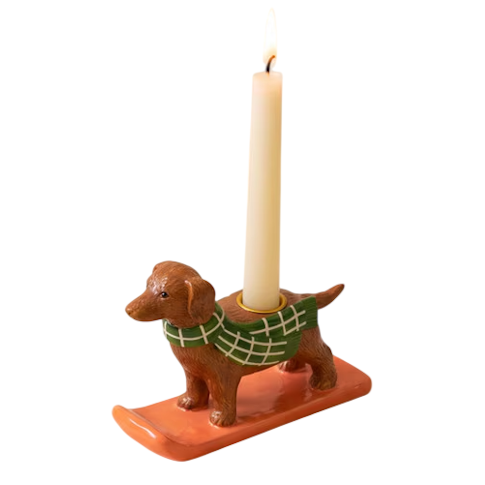 Ceramic dachshund taper candleholder wearing a green plaid scarf on a coral sled.
