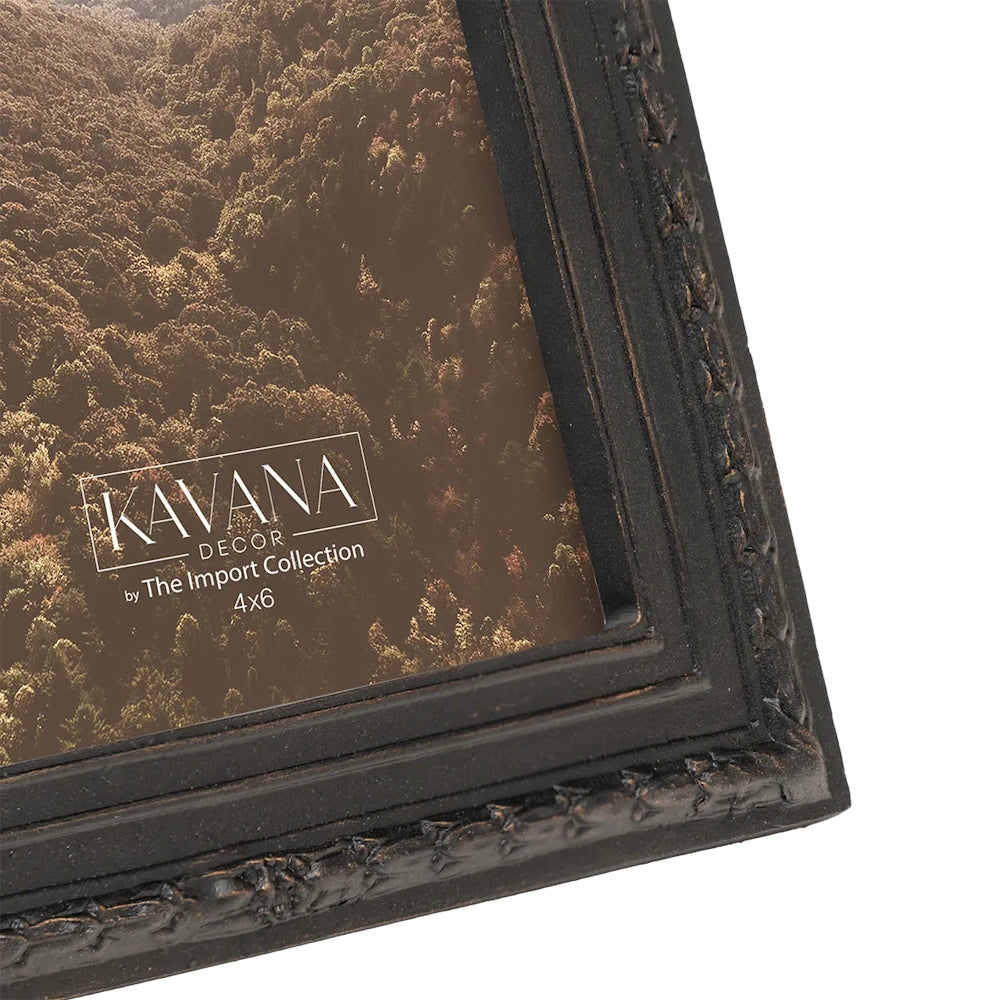 Close-up of a dark, ornate Kavana Decor picture frame with an aerial forest photo inside.